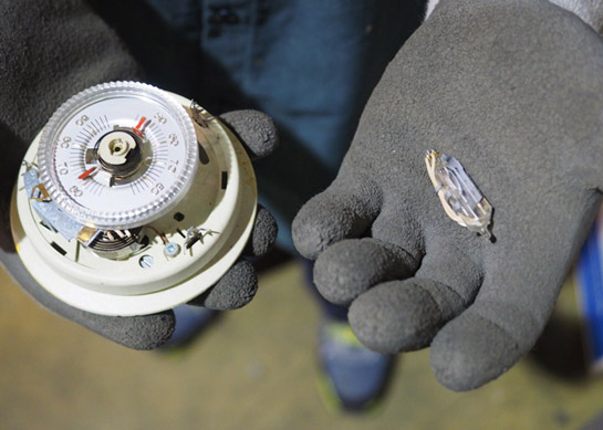 A picture of a thermostat and a small vial of mercury pulled from the device. NLR recycles mercury containing devices including thermostat, mercury switches, and medical equipment.